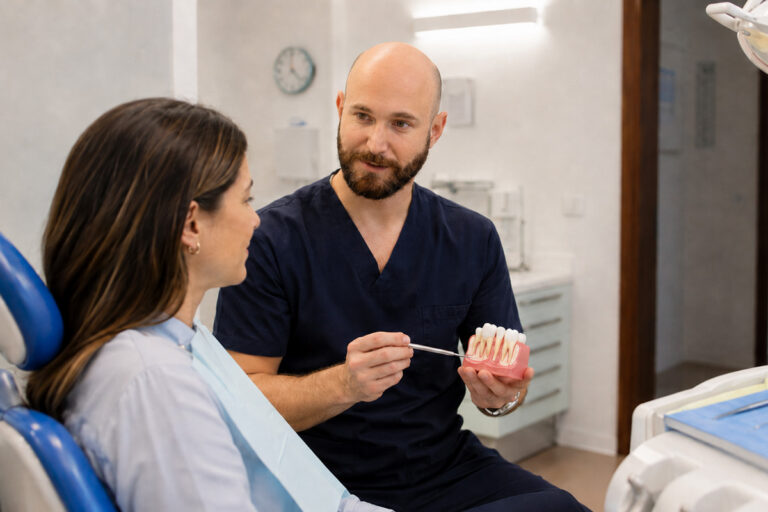 L'odontoiatra spiega a una paziente lo stato delle gengive su un modello dentale